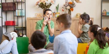 Teacher engaging young children in a classroom lesson.