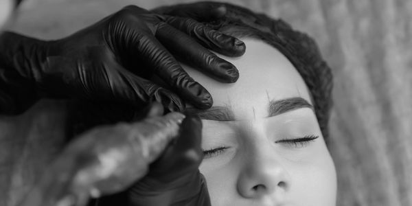 Close-up of microblading procedure on eyebrows.