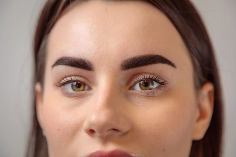 Close-up of a young woman with perfect eyebrows after a microblading treatment, highlighting the precision and artistry of the procedure
