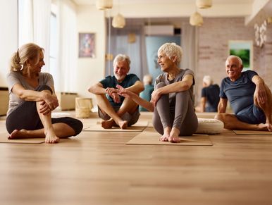 Seniors enjoying a yoga session together in a bright studio.
