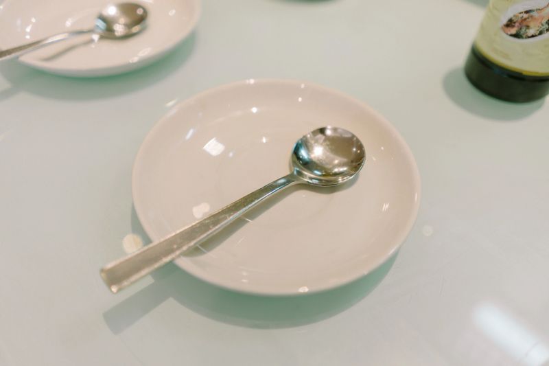 Spoon and plate set neatly arranged, ideal for dining table settings in a restaurant or home
