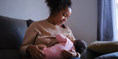 Woman breastfeeding her baby on a couch.