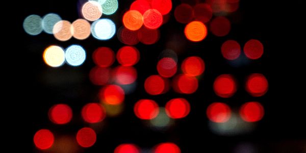 Out-of-focus city traffic lights creating colorful bokeh effect at night.