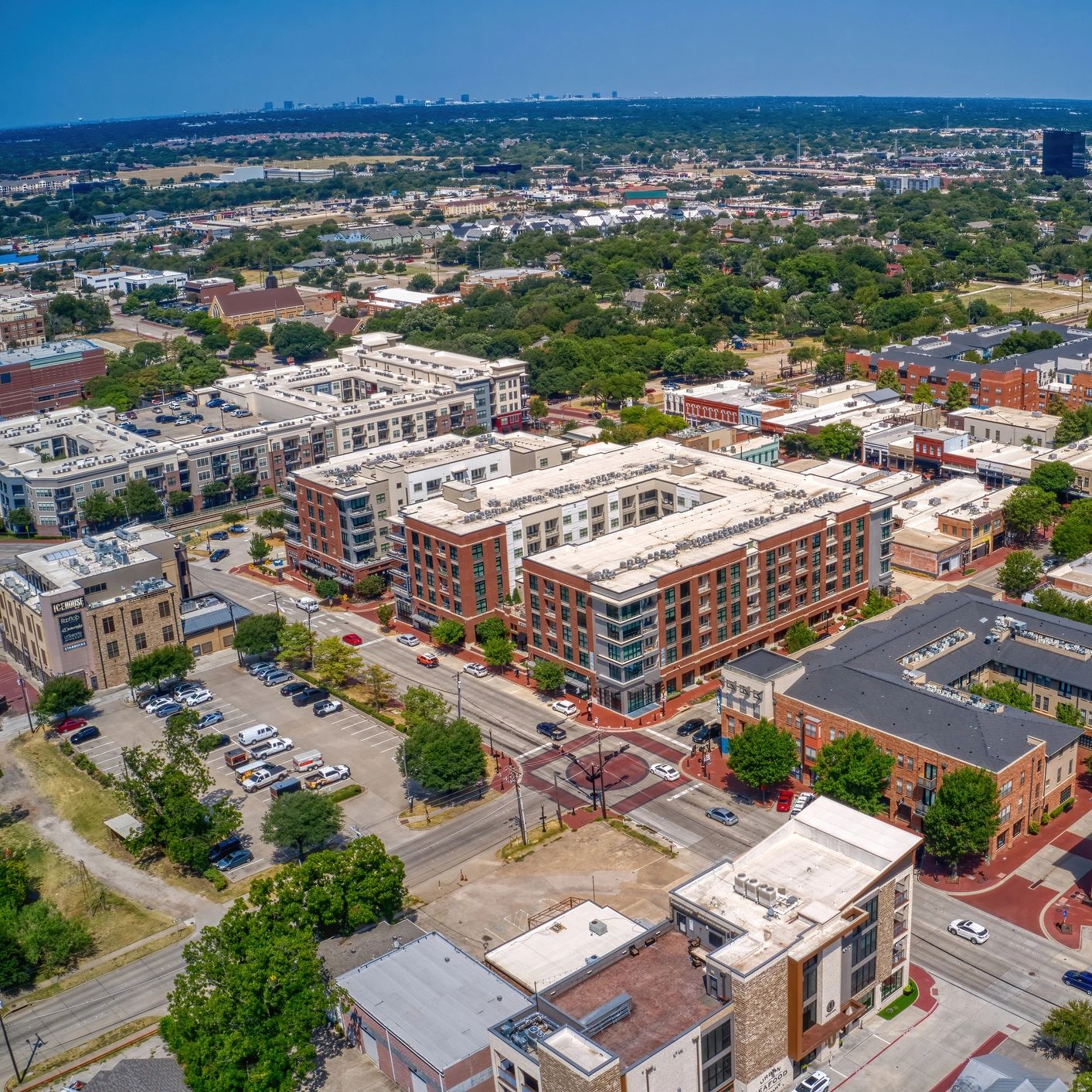 Aerial view of a city neighborhood with modern buildings and greenery.