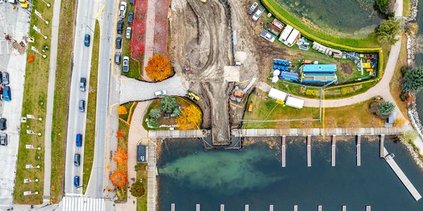 Aerial view of a marina with boats docked and nearby road.