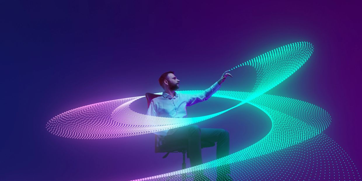 Man interacting with vibrant digital light waves in a futuristic setting.