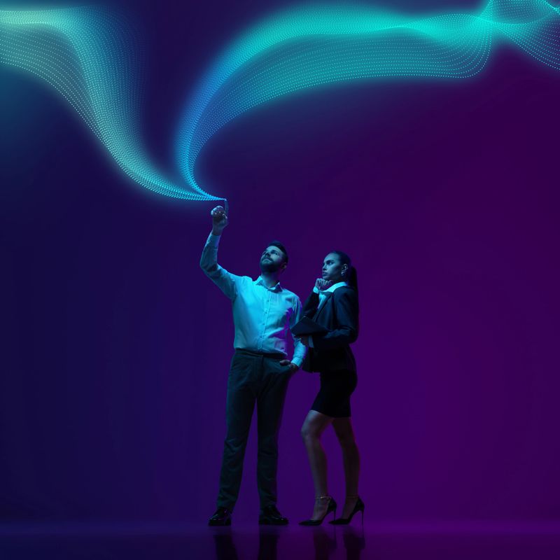 Man and his assistant in formal suits, interacts with flowing waves of digital data, symbolizing leadership in age of technology. Concept of scientific discovery and innovation, network, information.