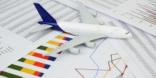Model airplane on financial charts and data sheets.