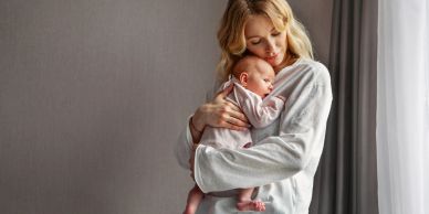 Mother holding newborn baby close.