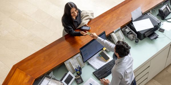 A woman checking in at a reception desk.