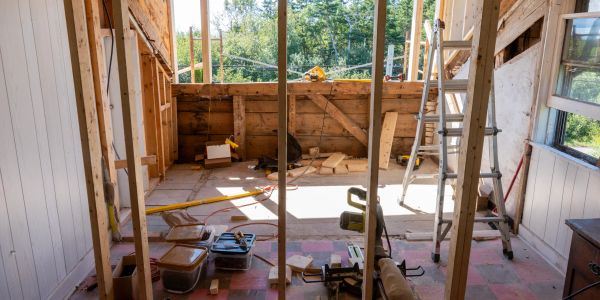 Room under construction with wooden beams and tools.