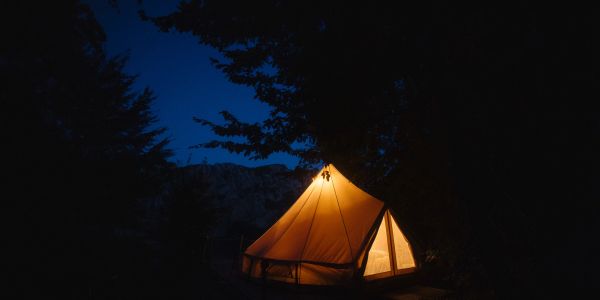 Illuminated tent glowing in the dark night.