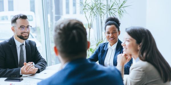 Four diverse professionals engaged in a positive business meeting.