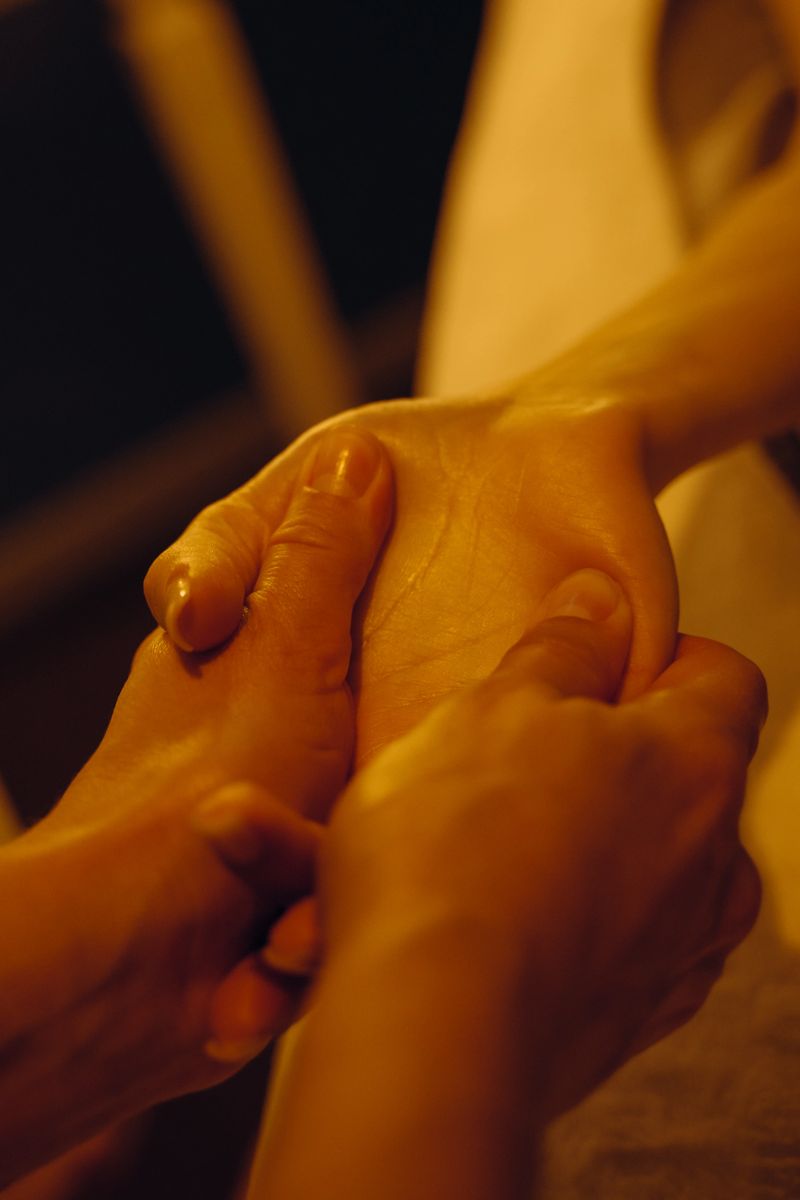 Spa treatment: Aromatherapy and hand massage. A client enjoys a soothing hand massage in a candlelit room