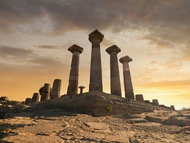 Ruinas de columnas antiguas al atardecer.