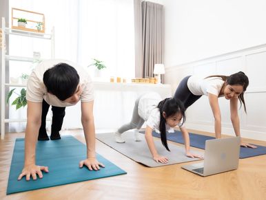 Family doing yoga together at home.
