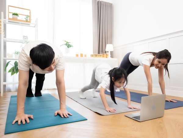 Family doing yoga together at home.