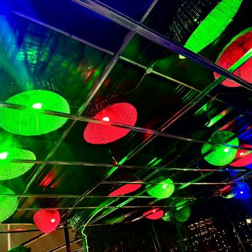 Colorful green and red circular lights on a ceiling structure.