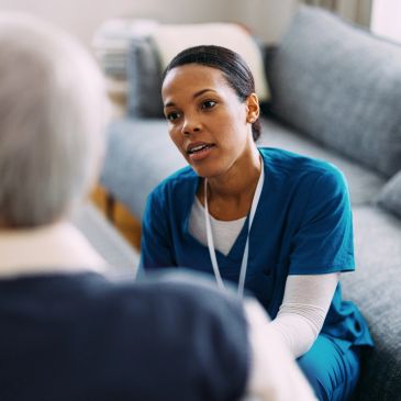 Nurse attentively listening to elderly patient.