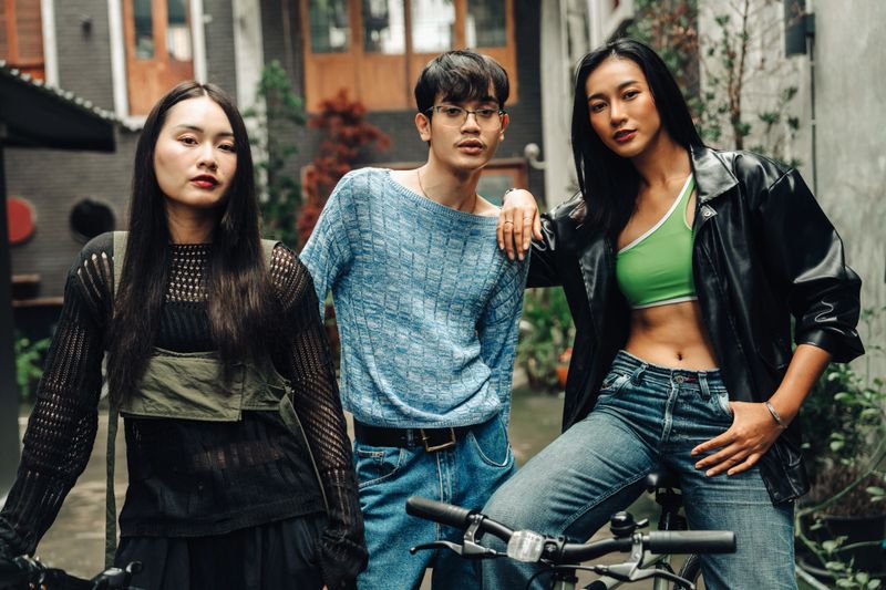 Group of fashionable young adults standing together in an alleyway, showcasing cool street style and individuality. Great for urban fashion and contemporary lifestyle themes.
