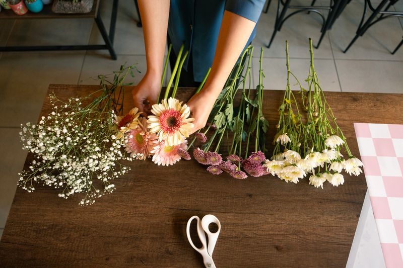 Woman's hand preparing flower bouquet in flower shop