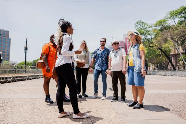 Tour guide speaking to a diverse group outdoors.