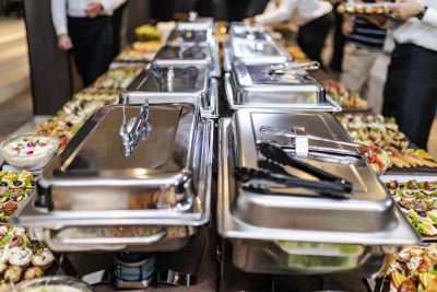 Buffet with chafing dishes and assorted foods.