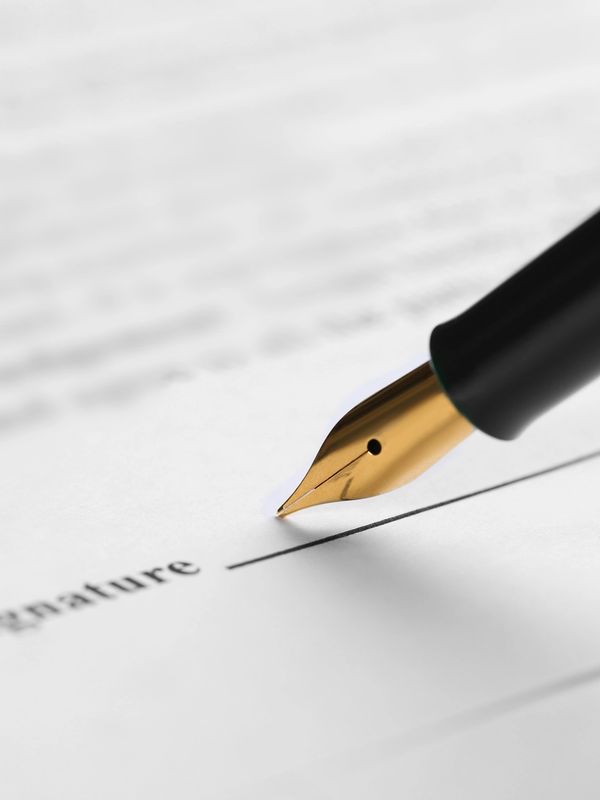Close-up of a fountain pen poised to sign a document.