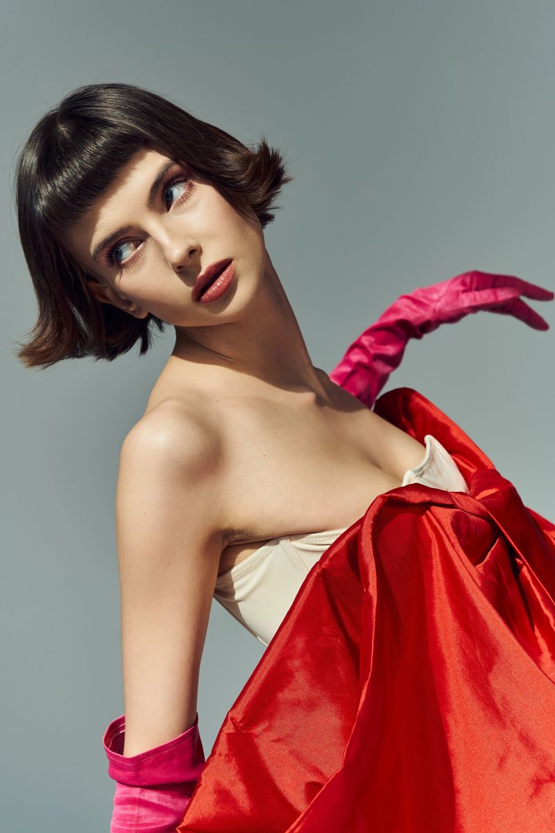 A beautiful woman showcases a fashionable dress, captivating with her stylish presence and poise.