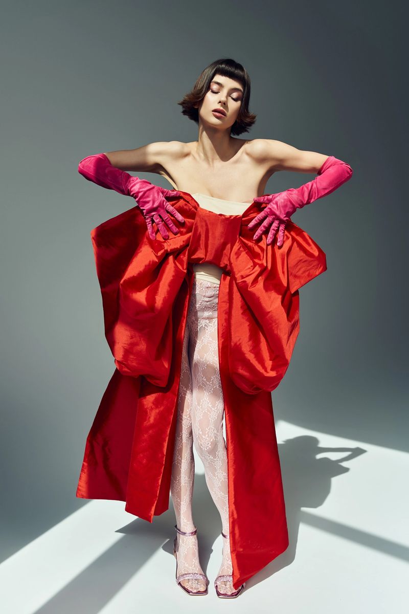 The beautiful woman poses gracefully in a striking red outfit, highlighting her fashion sense.