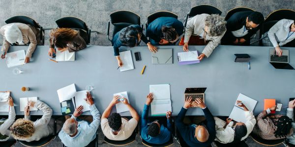 Overhead view of diverse professionals collaborating around a large table.