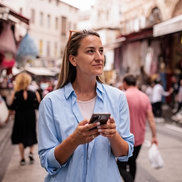 donna con smartphone in mano in centro città