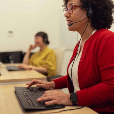 Customer support representatives working with headsets in an office.