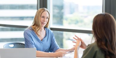 Two women having a conversation in an office.