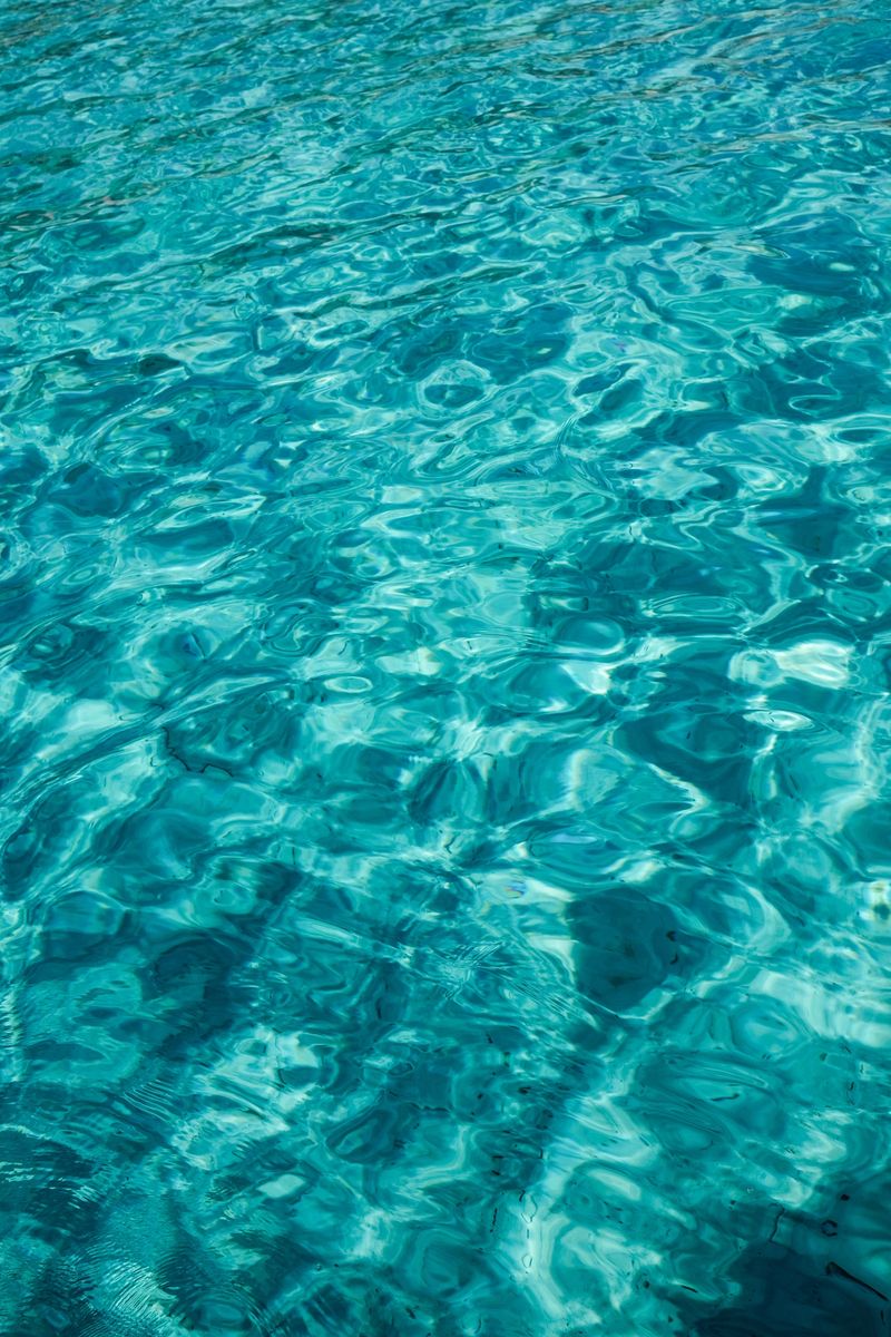 A tranquil view of clear turquoise ocean water with mesmerizing wave patterns creating a soothing effect. Perfect for backgrounds or nature-themed projects, evoking calm and serenity.