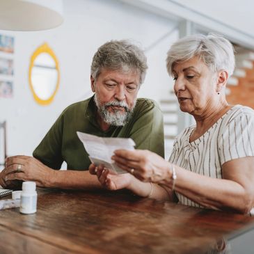 Elderly couple reviewing a document together at home.