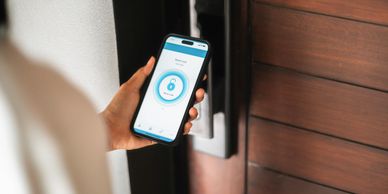 Person using a smartphone app to lock a smart door lock.