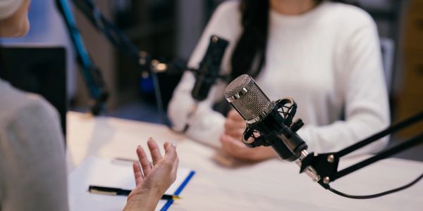 Two people recording a podcast with microphones.