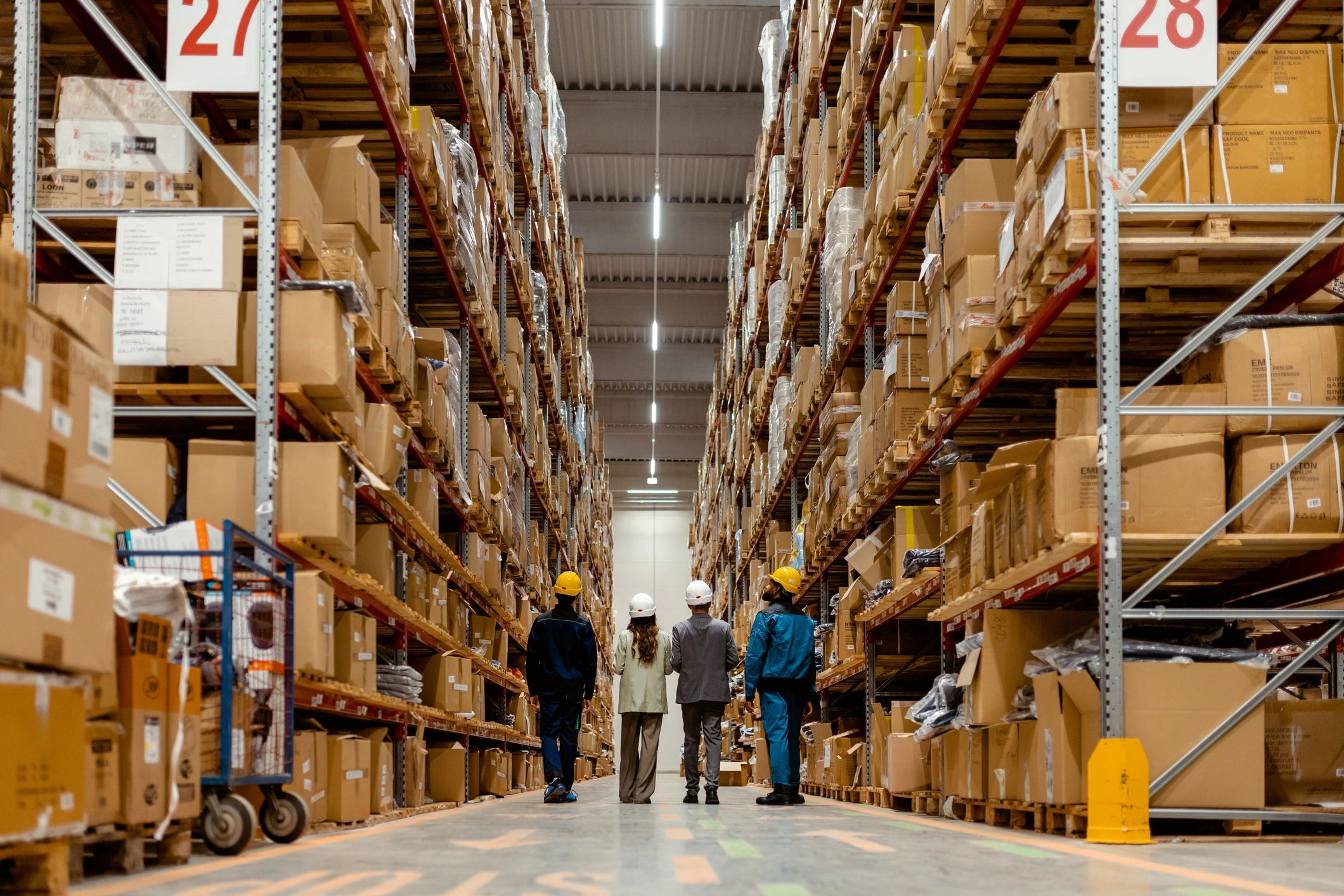 People walking in a large warehouse aisle.