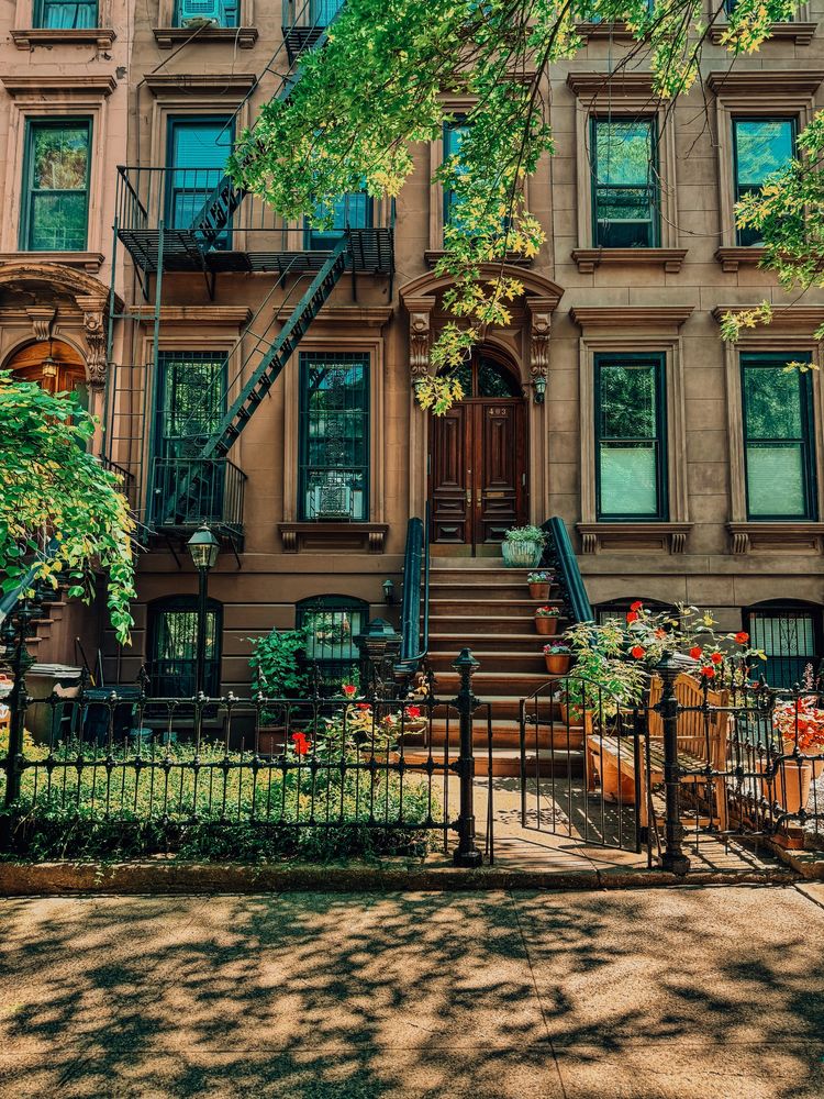Facade of multi-family townhouse front doorstep and windows in Brooklyn, NY. 