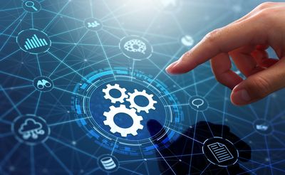 A finger is pointing at a gear icon on a computer screen.