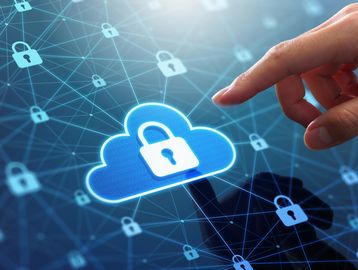 Hand interacting with a digital cloud security icon amidst a network of locks.