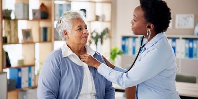 Doctor uses stethoscope to check elderly woman's heartbeat during a consultation.