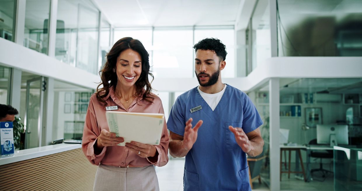 Two healthcare professionals discussing a file in a modern clinic.