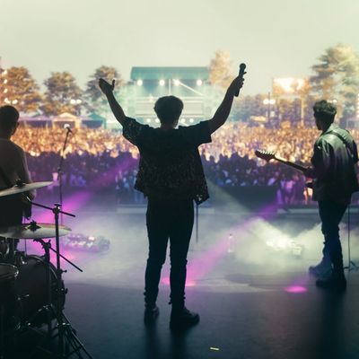 Band performing on stage in front of a large audience.