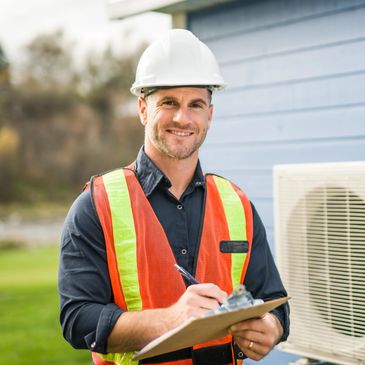 HVAC technician in safety gear smiling with clipboard.