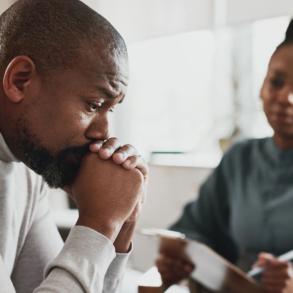 A man looks worried while talking to a counselor.