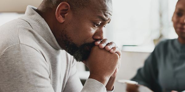 Man looking worried and deep in thought during a conversation.