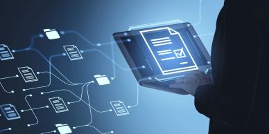 Person holds laptop with digital documents floating beside them.