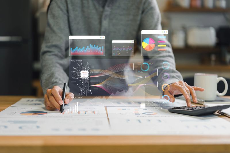 Analyzing data and creating visual reports with graphs and charts, person engages in strategic planning and decision making in modern workspace.